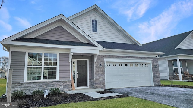 view of front of house with an attached garage, driveway, roof with shingles, and stone siding