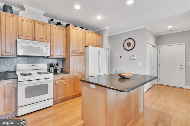 kitchen with ornamental molding, white appliances, and a kitchen island