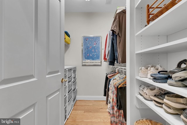 walk in closet with light wood-style flooring