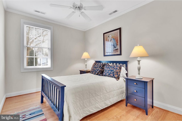 bedroom featuring ornamental molding, wood finished floors, visible vents, and baseboards