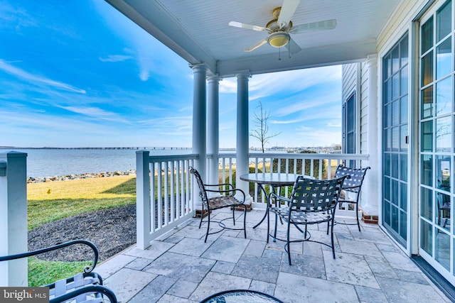 exterior space featuring ceiling fan and a water view