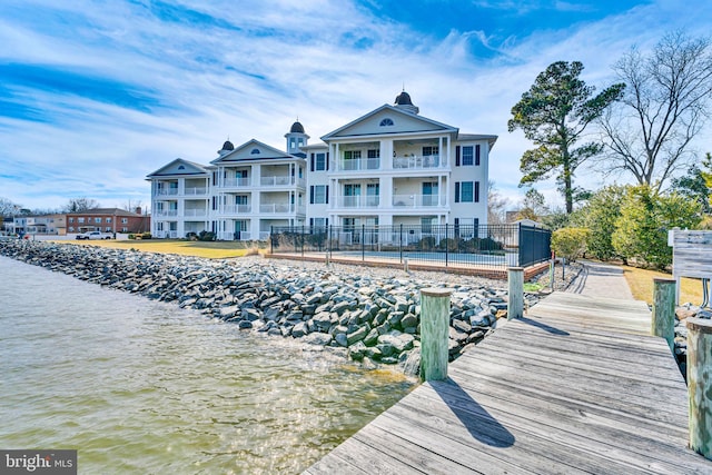 dock area with a water view and fence