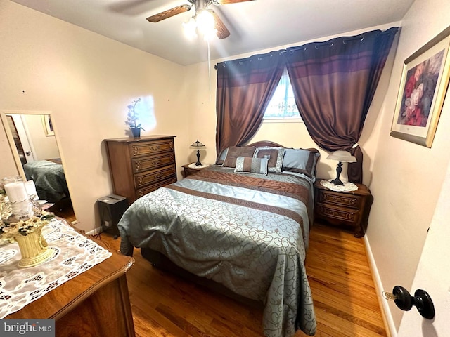 bedroom featuring dark wood finished floors, a ceiling fan, and baseboards