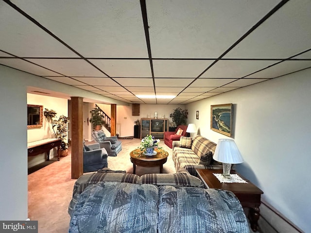 living room featuring a paneled ceiling, stairs, and carpet floors