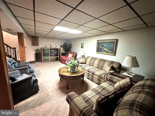 living room with a drop ceiling and carpet flooring