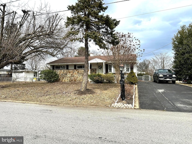 view of front facade with aphalt driveway and fence