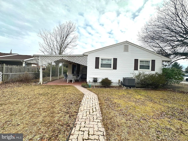 rear view of house with a patio area, fence, central AC, and a lawn