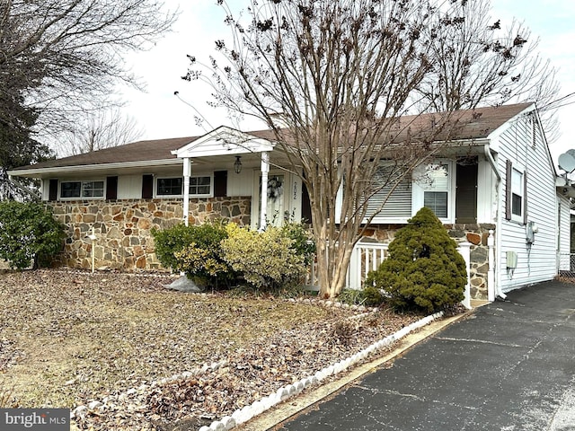 ranch-style house with stone siding and fence