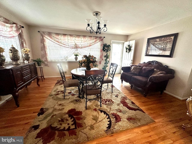 dining area with an inviting chandelier, baseboards, and wood finished floors