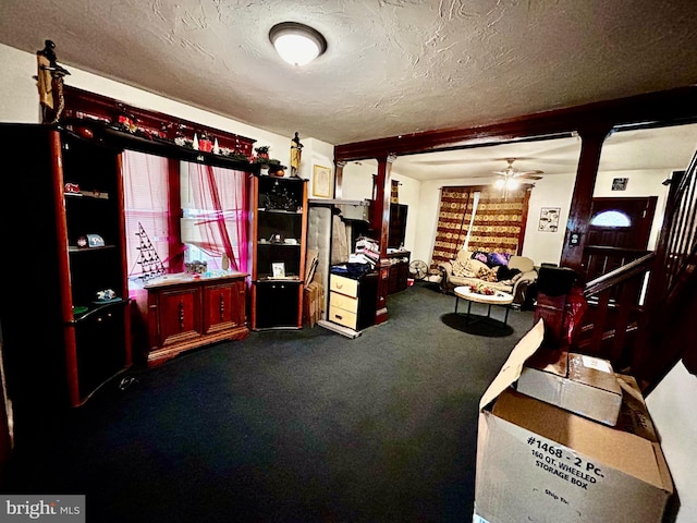 interior space with carpet, ceiling fan, and a textured ceiling