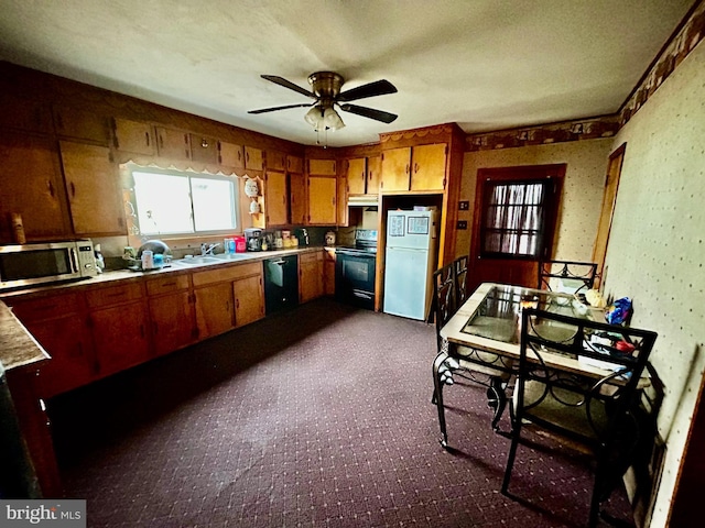 kitchen featuring under cabinet range hood, a sink, light countertops, black appliances, and brown cabinetry