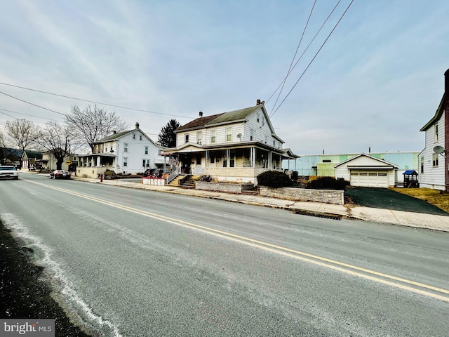 view of front facade featuring a porch, a residential view, and a detached garage