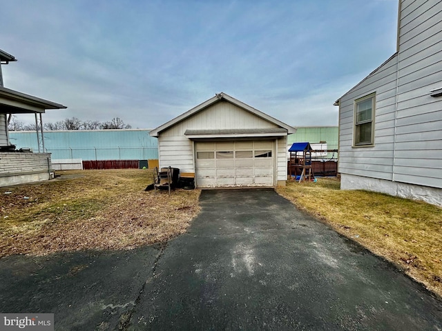 detached garage with driveway and fence