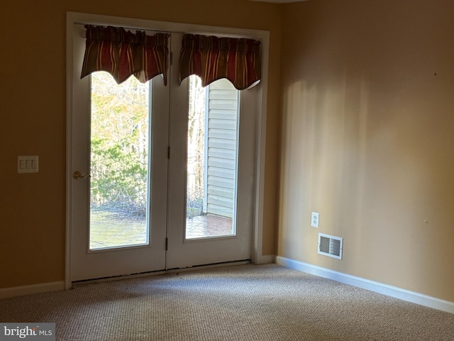 doorway with visible vents, plenty of natural light, and carpet