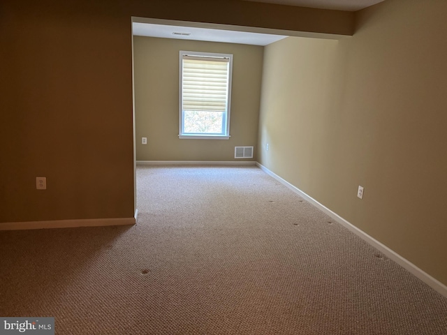 empty room with visible vents, baseboards, and carpet floors