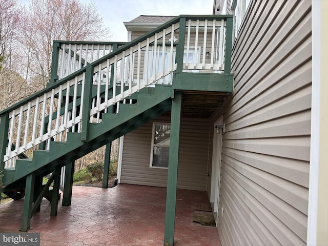 view of property exterior featuring a patio, stairway, and a carport