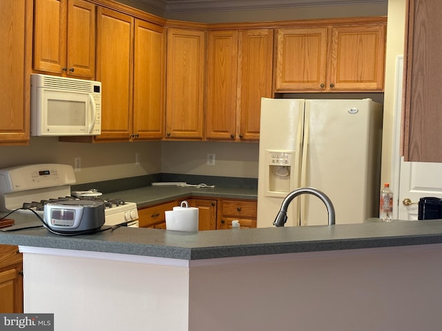 kitchen with white appliances, dark countertops, and a peninsula