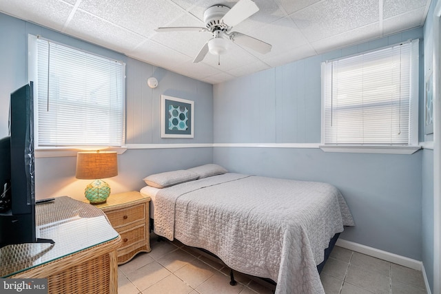 bedroom with light tile patterned flooring, a ceiling fan, and baseboards