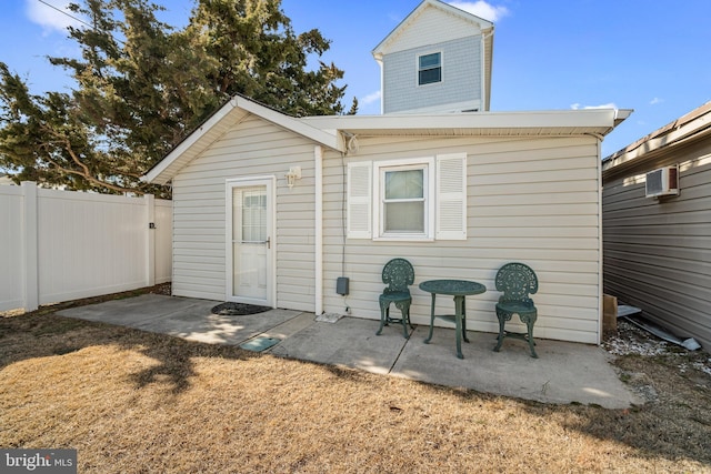 rear view of property with a patio area, fence, a lawn, and a wall mounted AC