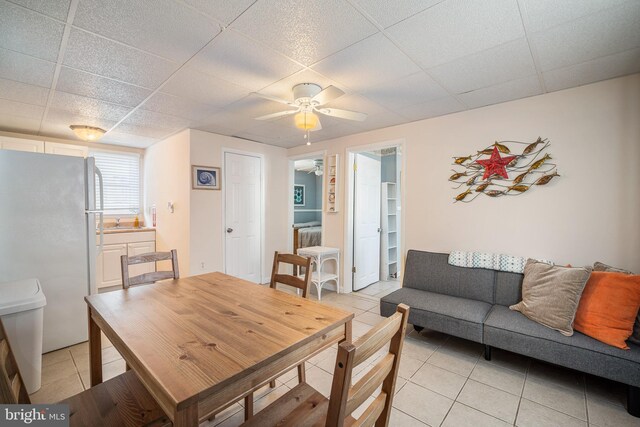 dining space with a paneled ceiling and light tile patterned floors