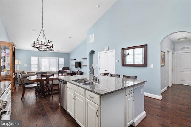 kitchen featuring visible vents, dishwasher, an island with sink, open floor plan, and a sink