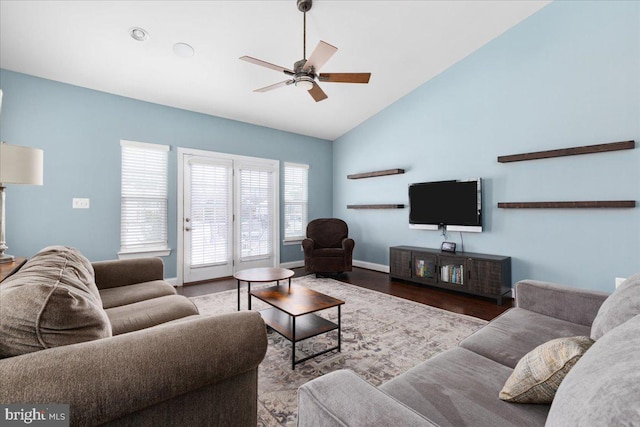 living area with ceiling fan, high vaulted ceiling, wood finished floors, and baseboards