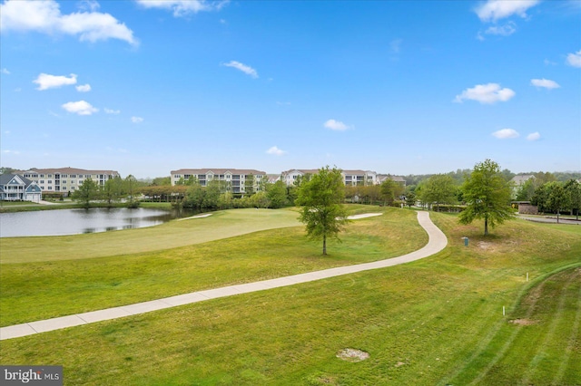 view of home's community with a water view and a lawn