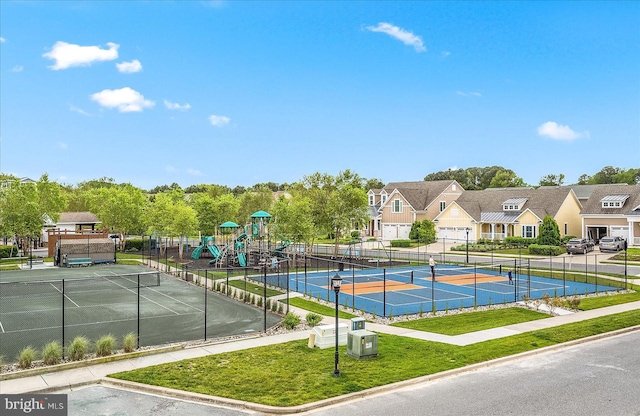 view of sport court featuring a lawn, a residential view, fence, and playground community