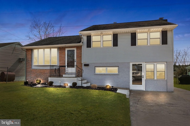 split level home with a yard, heating fuel, and stucco siding