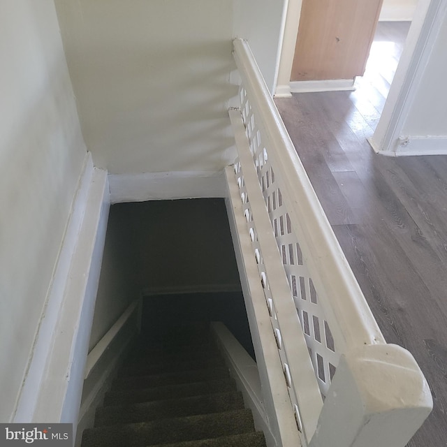 stairs featuring wood finished floors