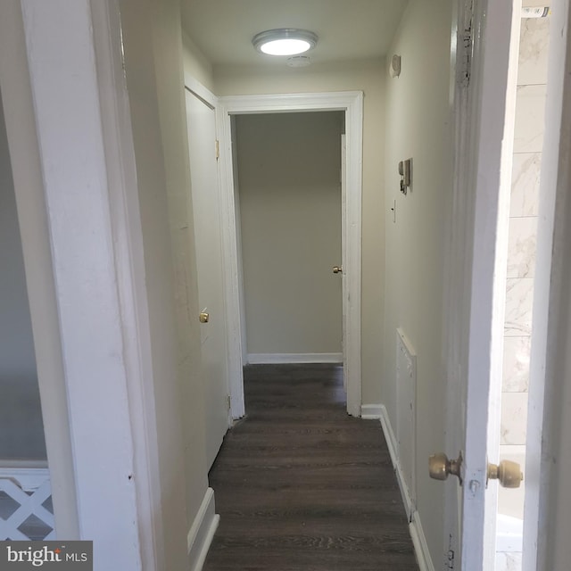 hallway with dark wood-style floors and baseboards