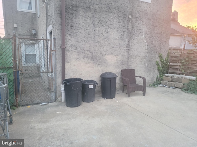 patio terrace at dusk featuring a gate