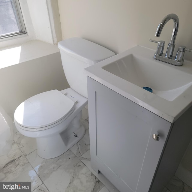 half bathroom with toilet, marble finish floor, and vanity