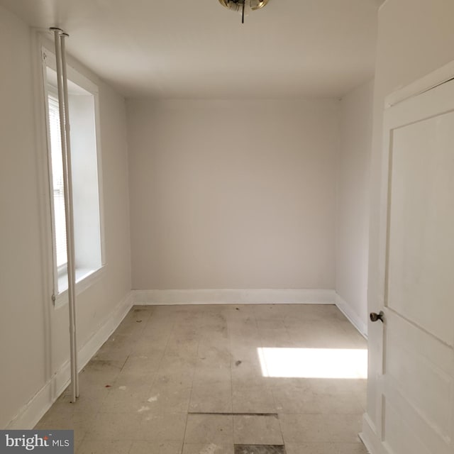 unfurnished room with baseboards