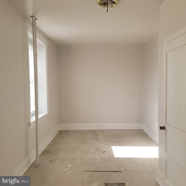 unfurnished room featuring baseboards