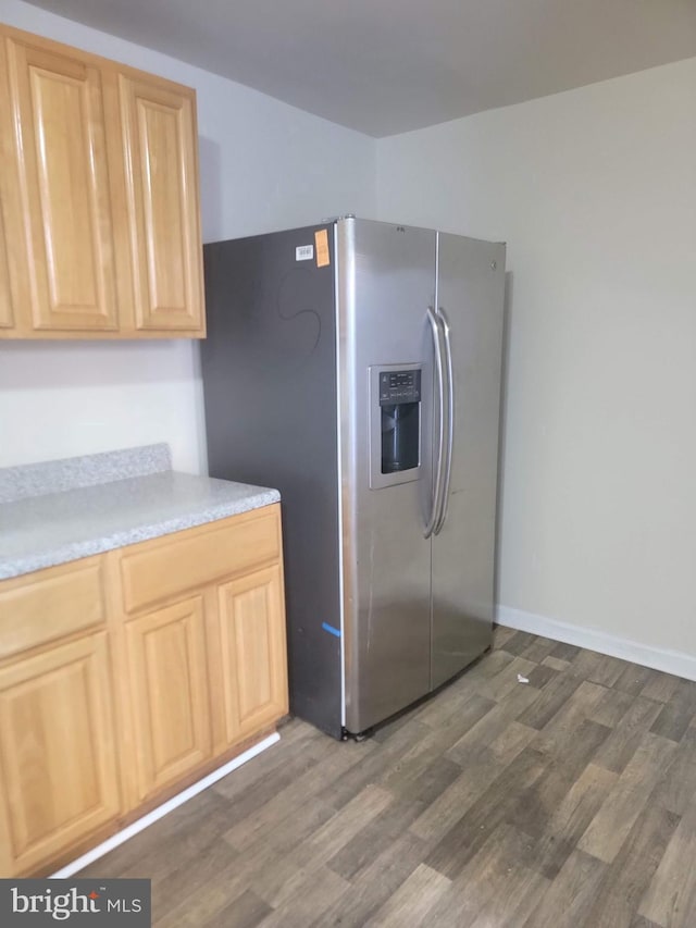 kitchen featuring dark wood-style floors, light countertops, stainless steel fridge with ice dispenser, and light brown cabinetry