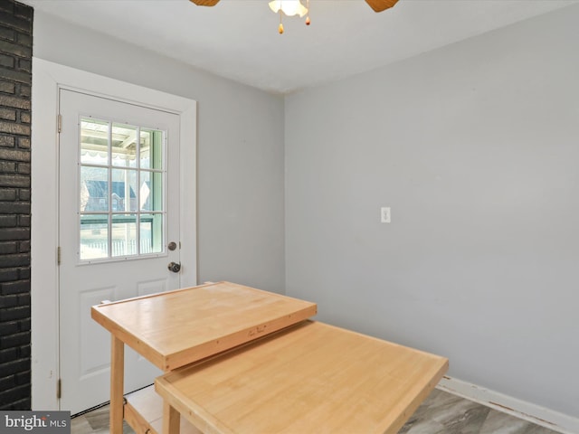 dining room featuring wood finished floors, a ceiling fan, and baseboards