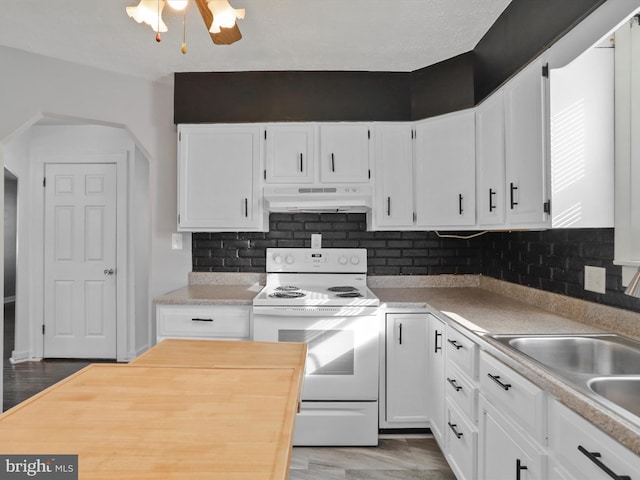 kitchen featuring white cabinetry, a sink, white range with electric stovetop, and under cabinet range hood