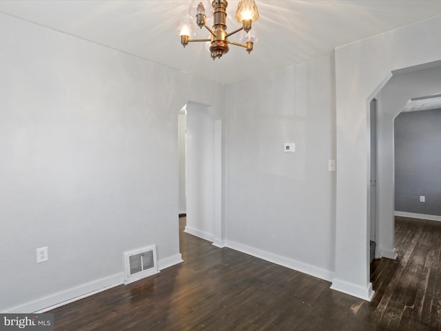 unfurnished room featuring arched walkways, a notable chandelier, dark wood-style flooring, visible vents, and baseboards