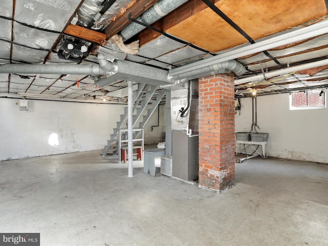 basement featuring stairs and heating unit