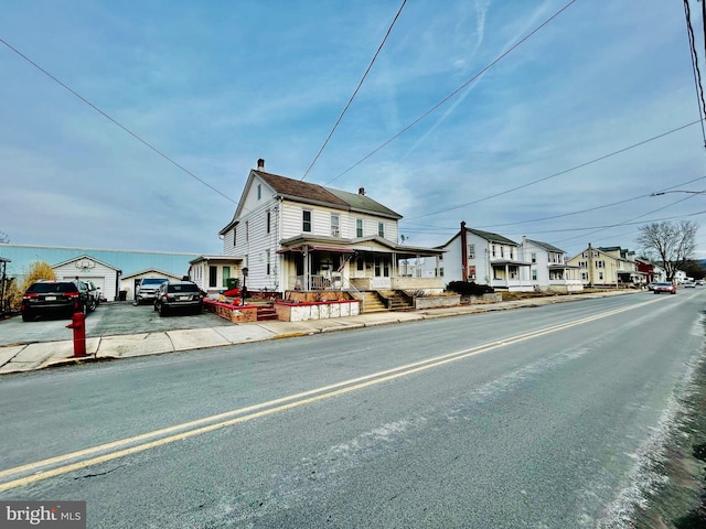 view of road featuring street lighting, a residential view, curbs, and sidewalks