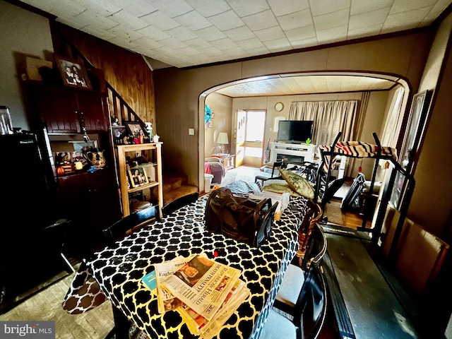 living area with arched walkways, ornamental molding, and a fireplace