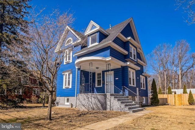 view of front of home featuring covered porch and fence