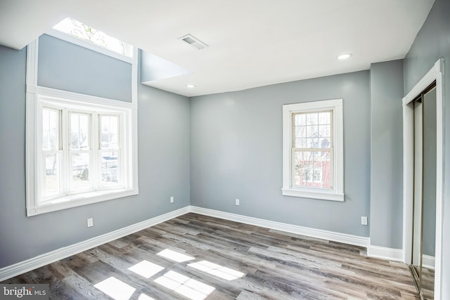 spare room with light wood-type flooring, baseboards, visible vents, and recessed lighting