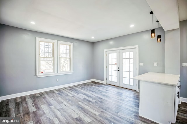 interior space featuring dark wood-style floors, french doors, baseboards, and a healthy amount of sunlight