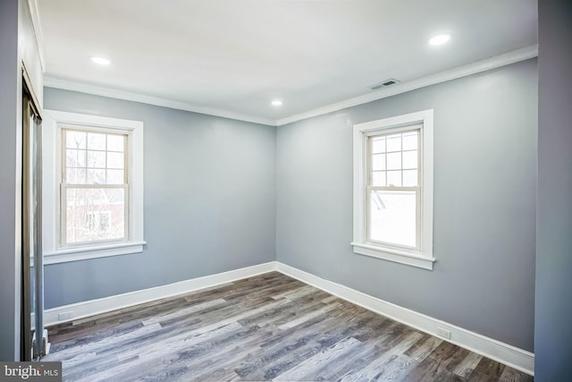 spare room featuring crown molding, visible vents, plenty of natural light, and baseboards