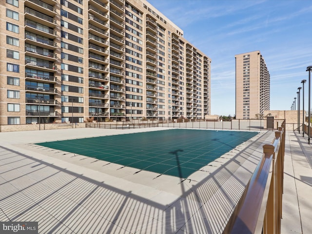 pool with a patio area and fence