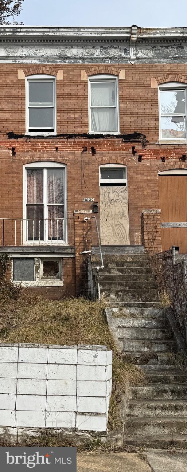 view of exterior entry featuring brick siding