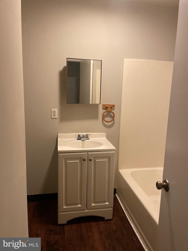 bathroom with vanity, wood finished floors, and a bathing tub