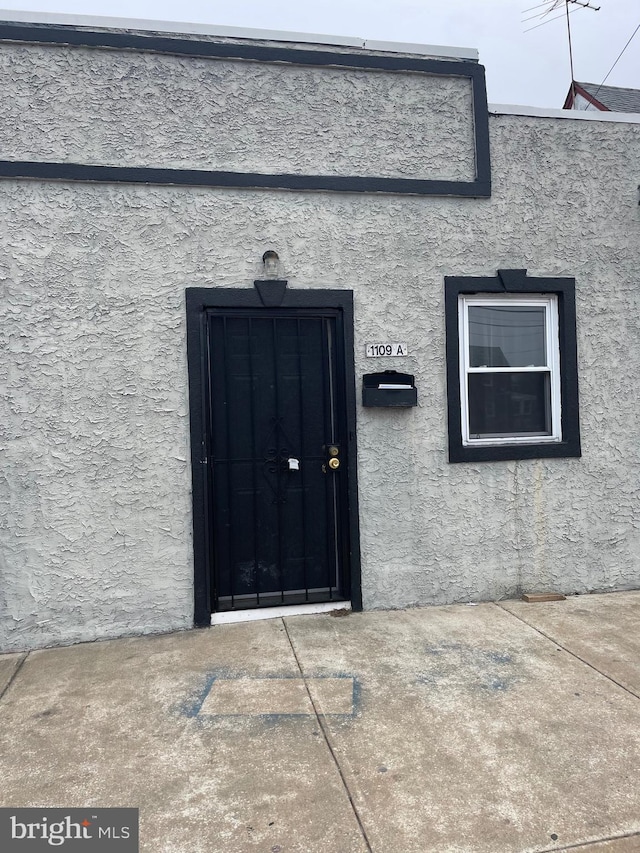 entrance to property with stucco siding